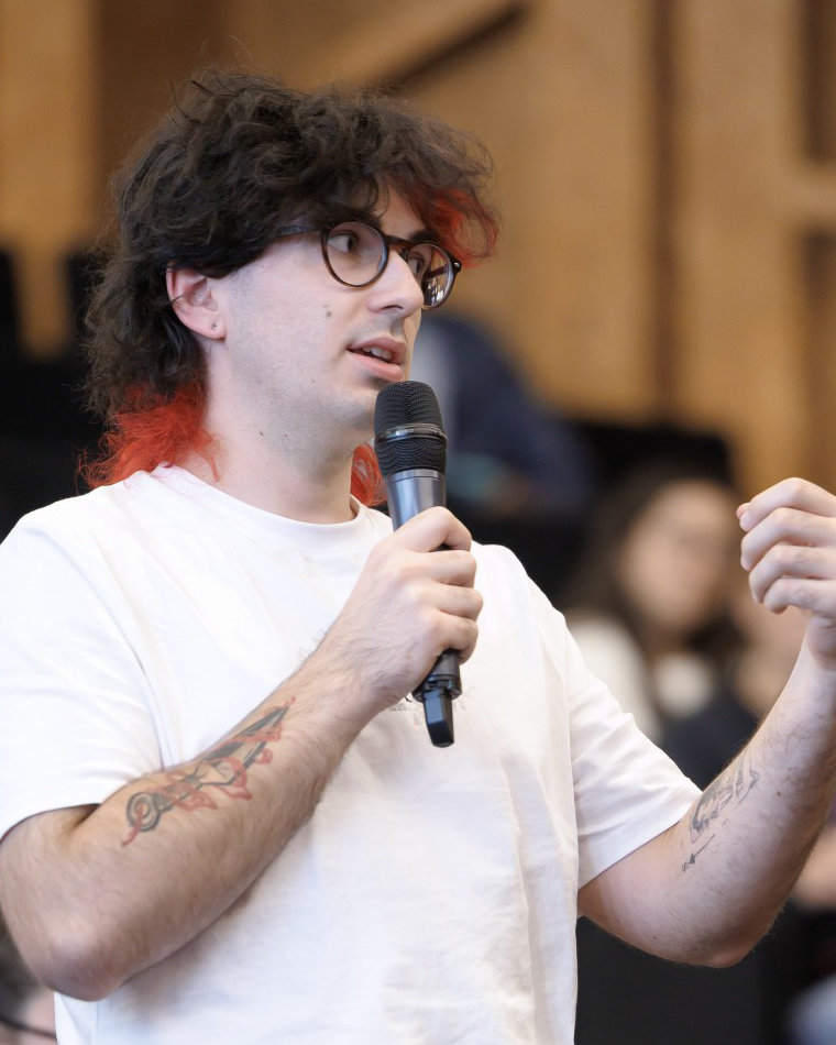 Alexandre au micro, posant une question pendant une conférence sur l'esport